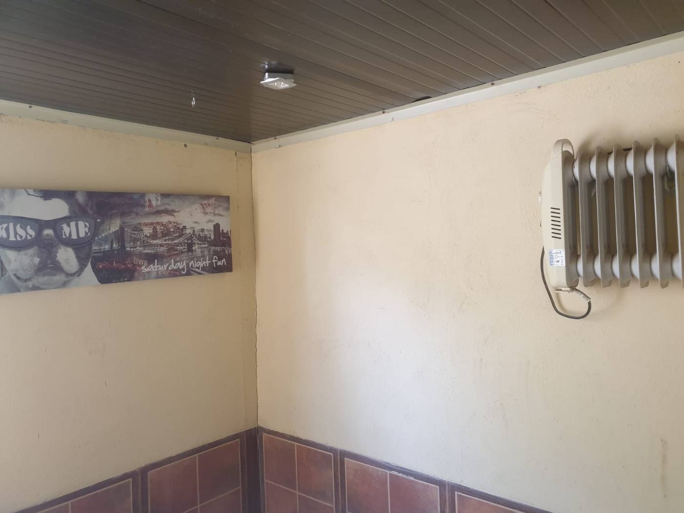 Interior de una habitación con radiador y zócalo de azulejo